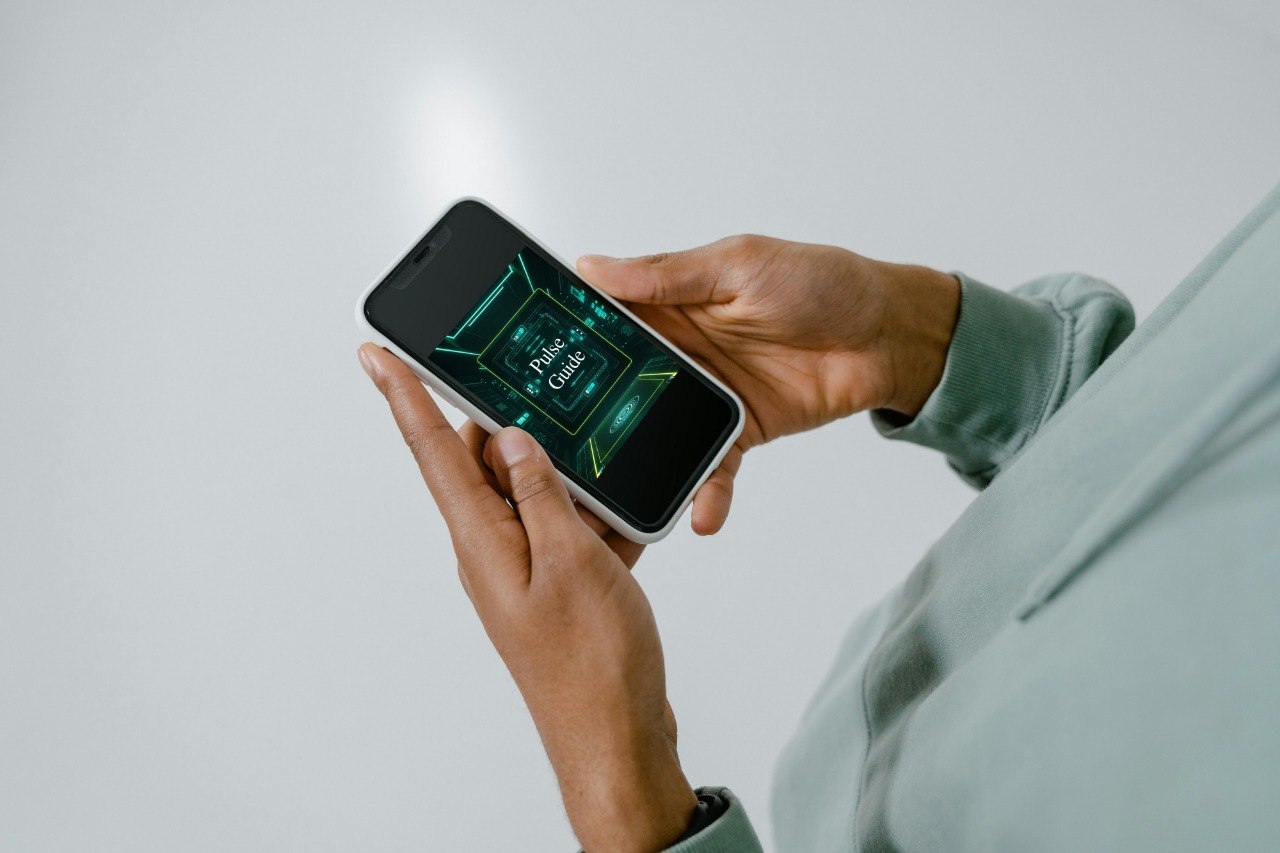 Person holding a smartphone with a green app interface on a plain background